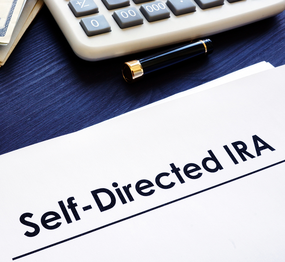 Self-Directed IRA SDIRA documents on a desk.